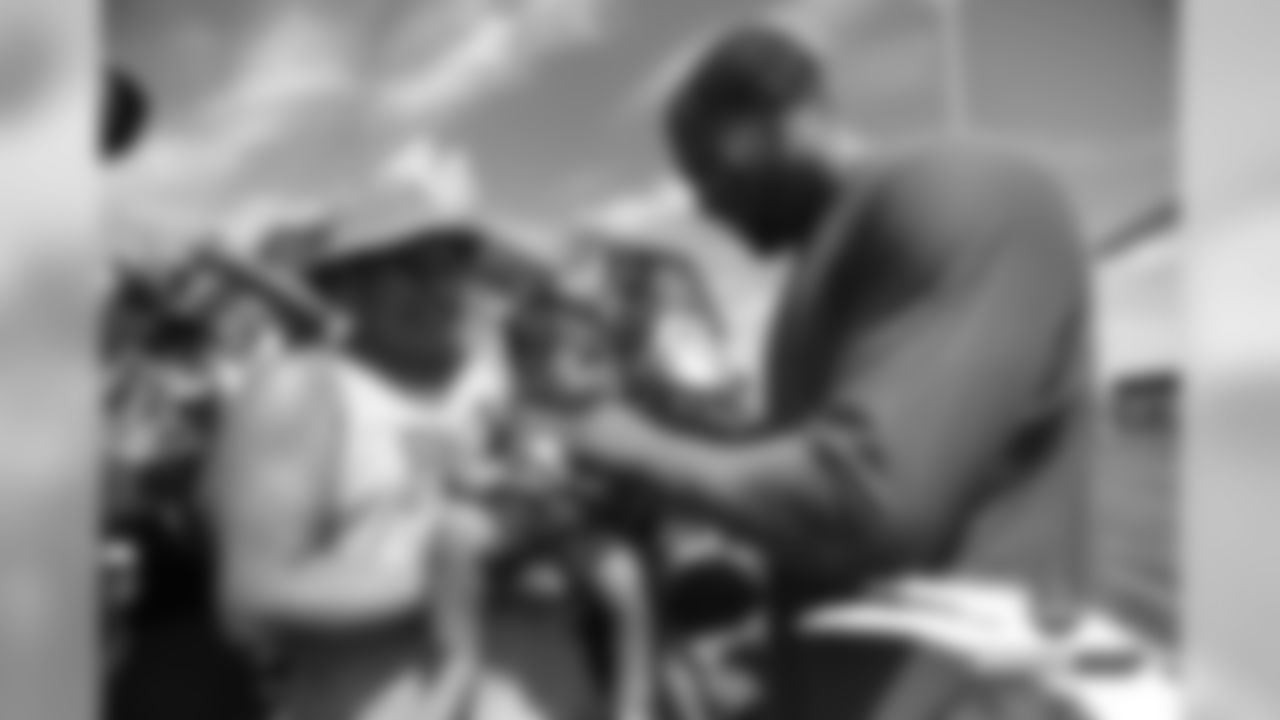 Bradley Chubb autographs a baby's jersey after practice on Day 8 of training camp on July 26, 2019.