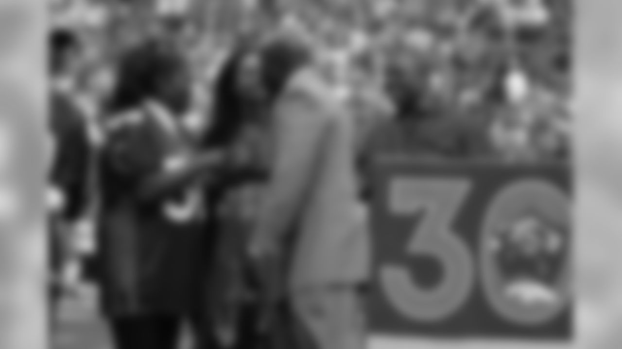 Terrell Davis talks with his mother and other members of his family at the conclusion of ceremonies for Davis's induction into the Ring of Fame at Invesco Field at Mile High.