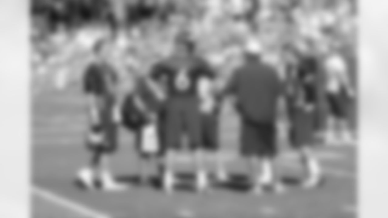 Peyton Manning and the rest of the quarterback group talk before practice.