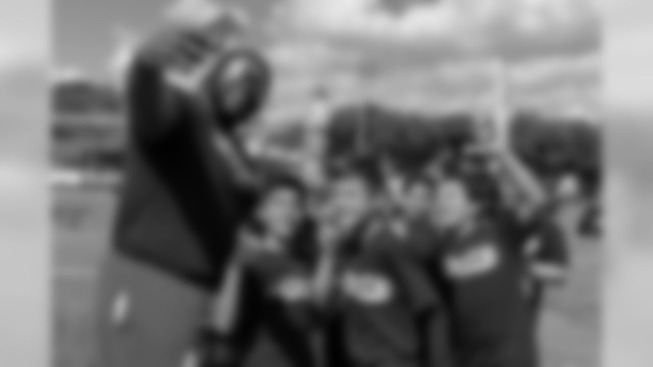 Zach Kerr takes a group photo with children during the Tochito National Tournament on February 9, 2019, as a player ambassador for the flag football tournament.