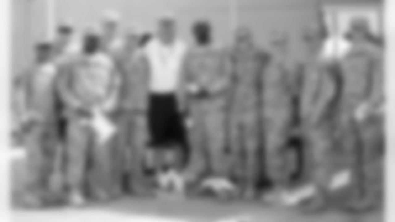 Head Coach John Fox takes a group photo with military members from Fort Carson.