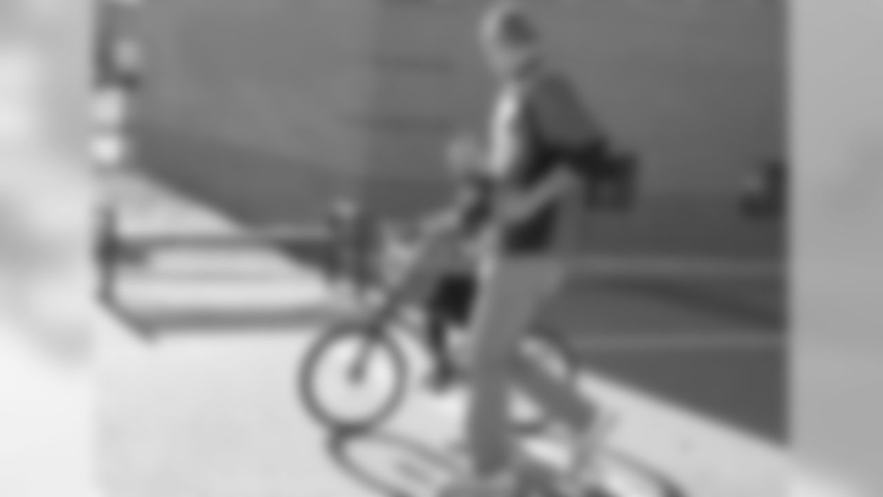 Tim Semisch runs alongside a bike rider during a bike distribution at Green Valley Elementary School in Denver on December 18, 2018.