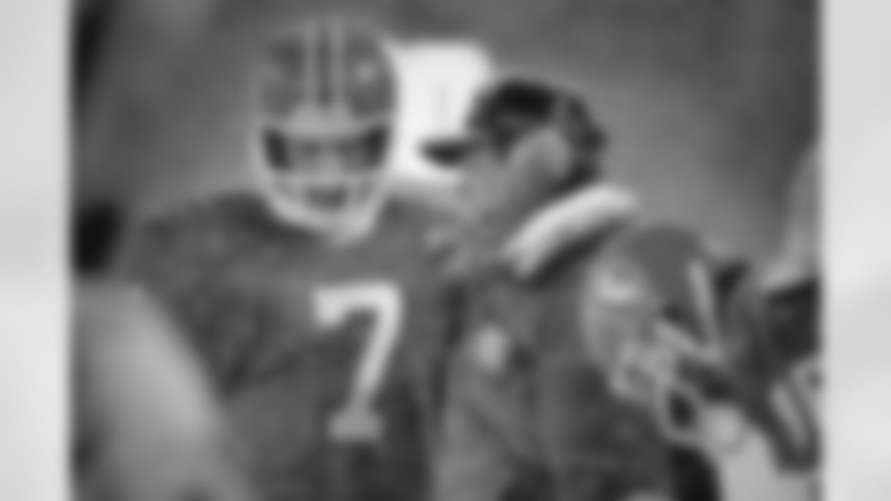 Quarterback John Elway and coach Dan Reeves talk on the sideline during a game.
