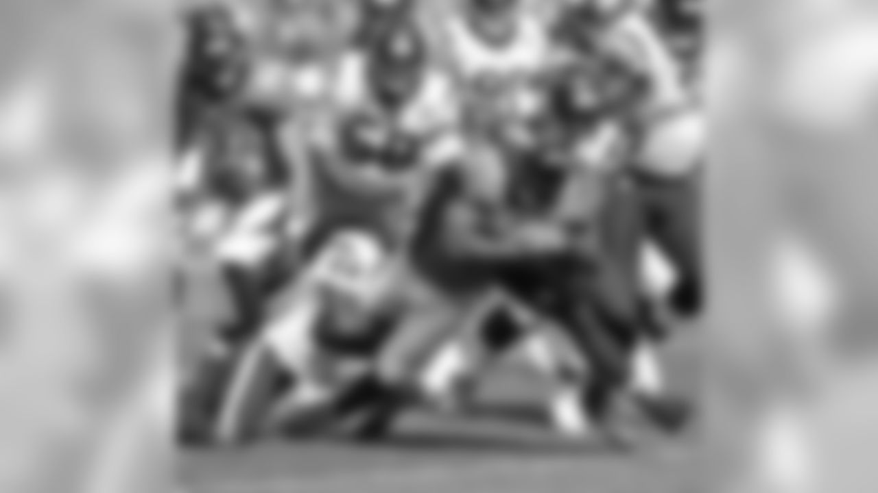 McGahee fights for yards as a gang of Texans try to bring him down.