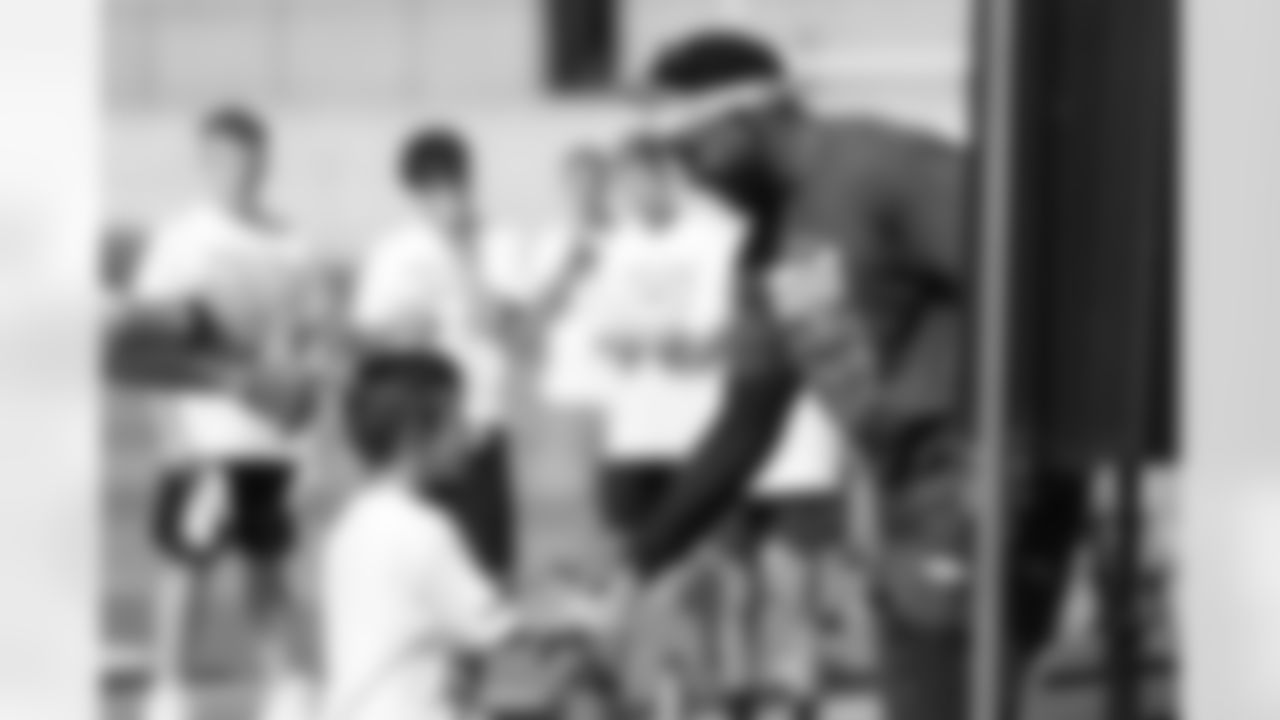 Melvin Gordon III shakes hands with a young fan at his youth football camp in Englewood, Colorado on June 29, 2021. (Photo by Ben Swanson)