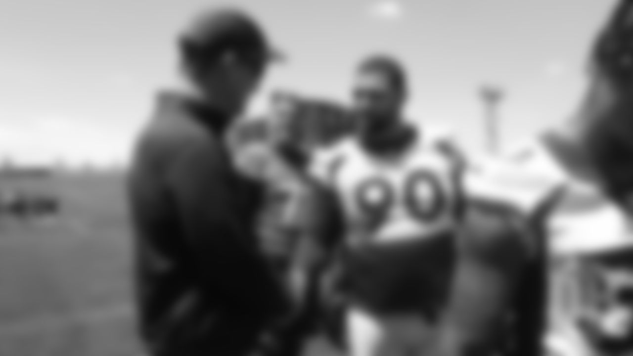 Billy Winn greets former Broncos quarterback Peyton Manning after the Broncos' practice on the eight day of their OTAs on May 30, 2019.