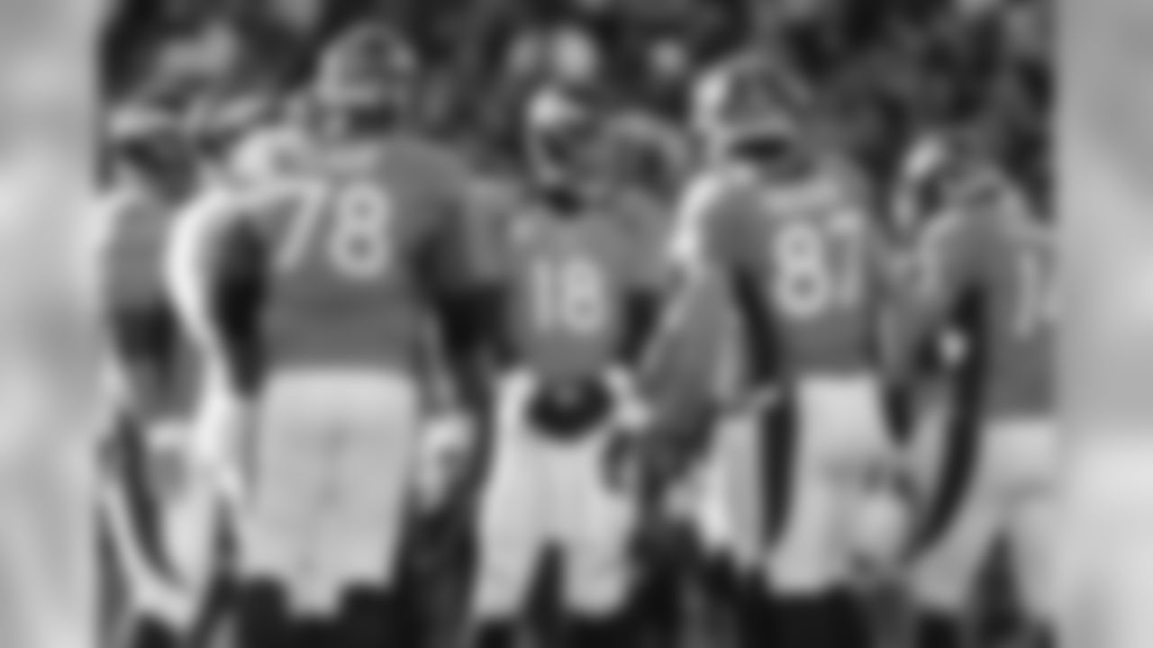Manning and the offense huddle up during first-half action against Cleveland.