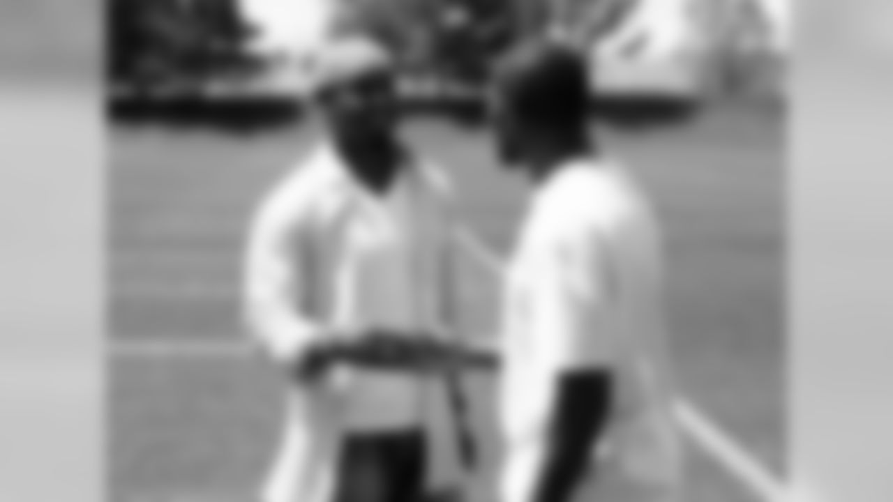 Dawkins greets Champ Bailey outside on the practice field.