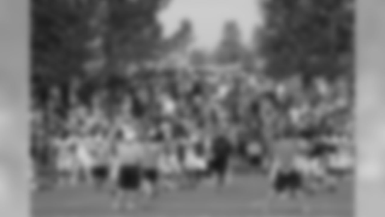 Broncos fans stretch with the team before practice.