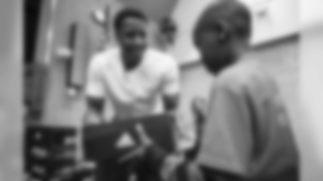 Children at Greenlee Elementary School receive shoes from Courtland Sutton as part of Shoes That Fit, an event with Snooze to help kids get shoes just before the holidays, on December 2, 2019. (Photo by Jeremy Rincon)