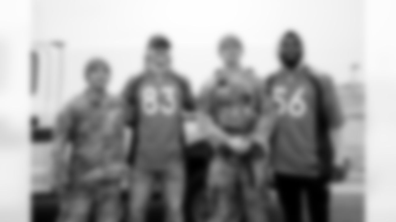 Andrew Beck and Baron Browning pose for a photo with military members during the Salute to Service Caravan presented by USAA at Buckley Space Force Base in Aurora, Colorado on November 2, 2021. (Photo by Ben Swanson)