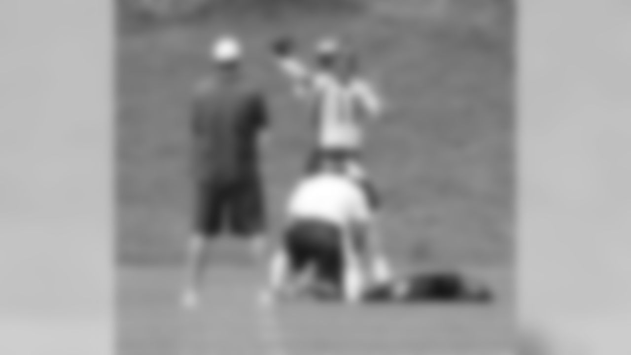 Manning fires a pass as QB Coach Adam Gase looks on.