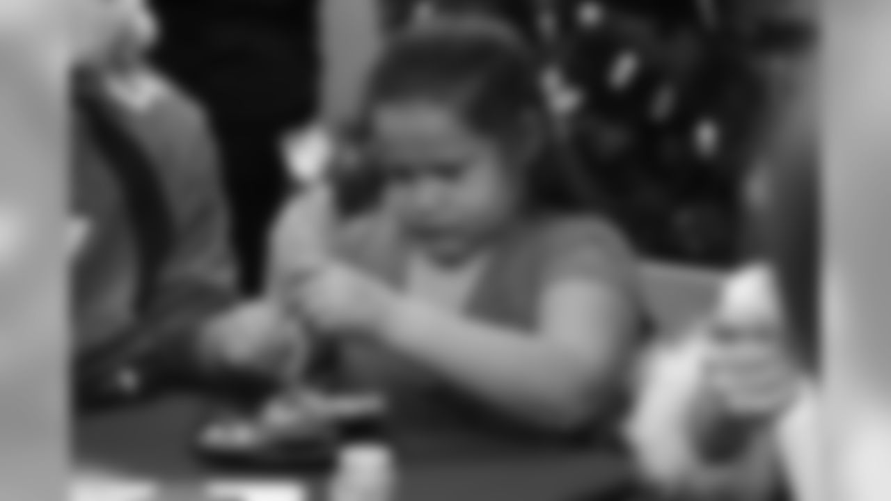 A young girl decorates gingerbread cookies at the Denver Rescue Mission's 19th annual holiday party.