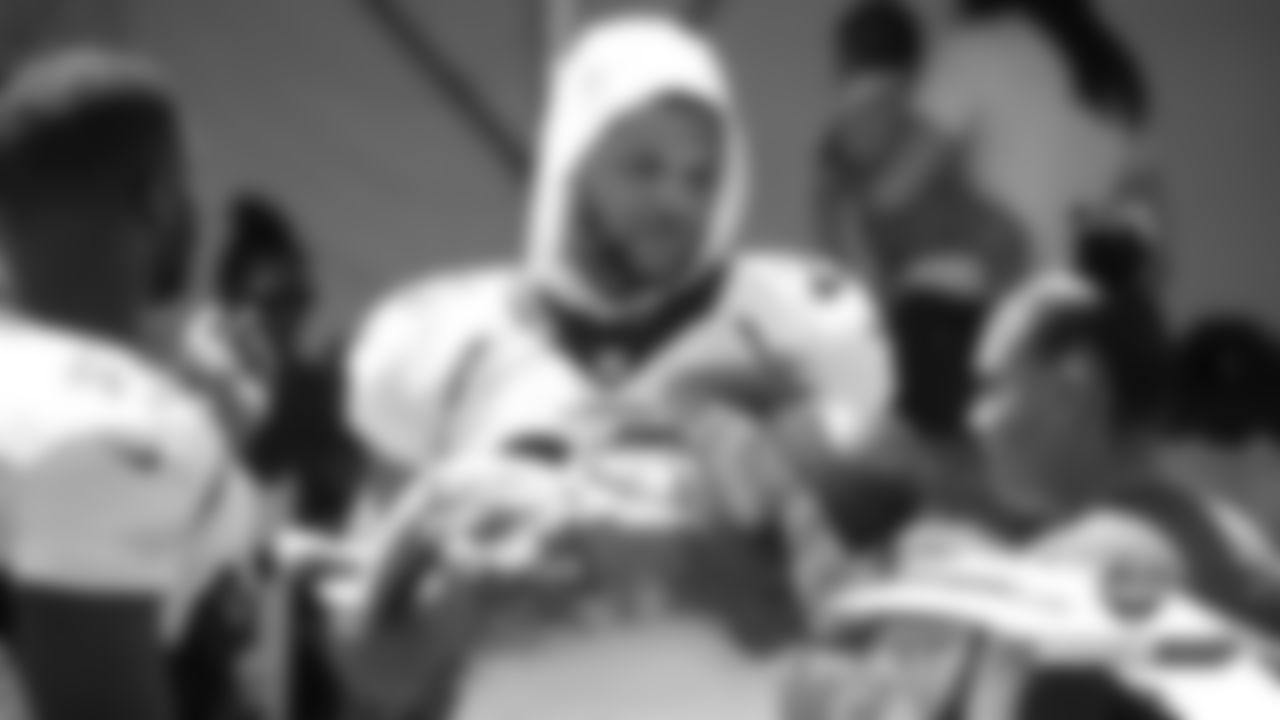 Devontae Booker holds his infant son after practice on Day 5 of training camp on July 22, 2019.