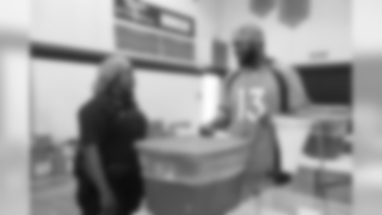 Aaron Burbridge talks with a police officer during a meal-packaging event with Feeding Children Everywhere at the Denver Broncos Boys & Girls Club on May 14, 2019, with volunteers from the Broncos, the Denver Police Department and the club.
