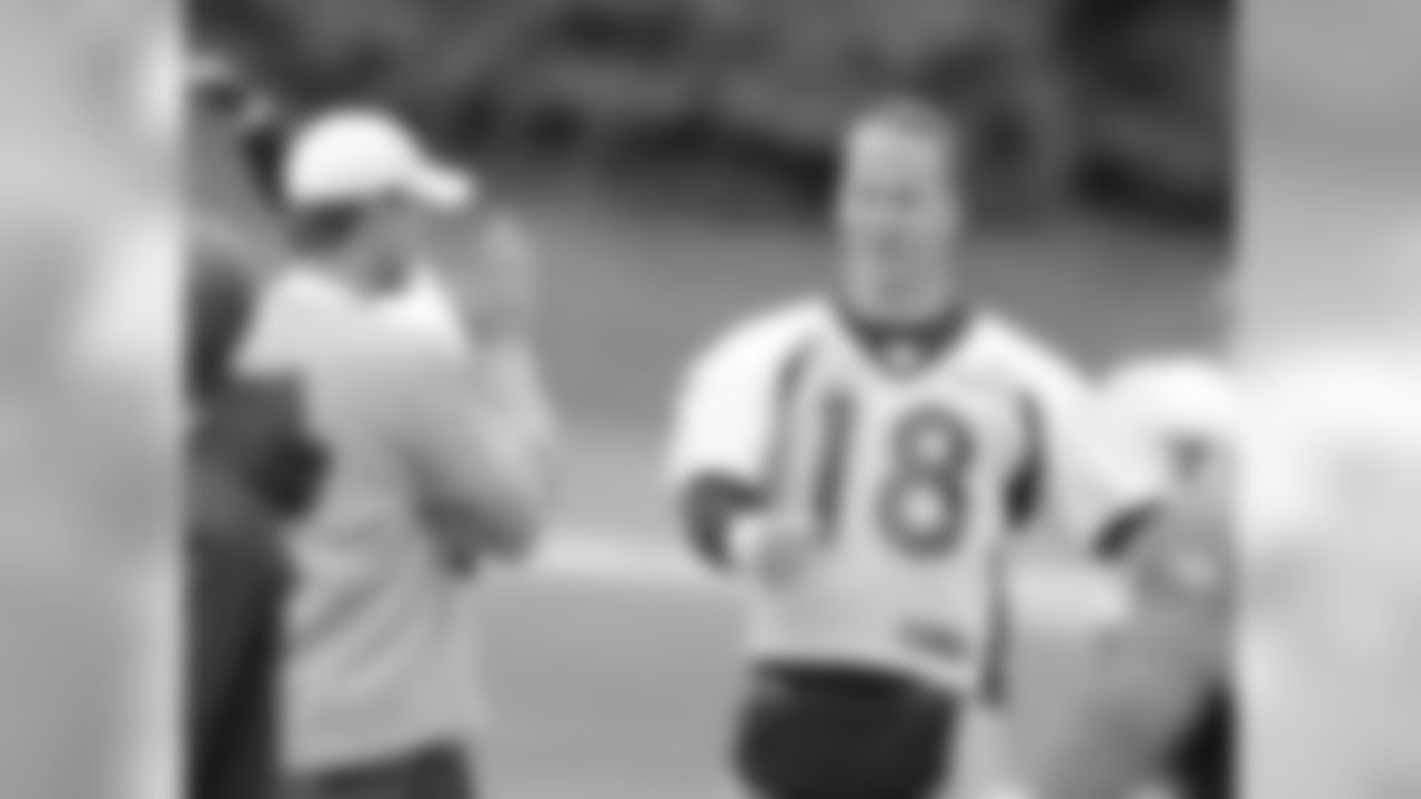 QB Peyton Manning chats with Quarterbacks Coach Mike McCoy while stretching.