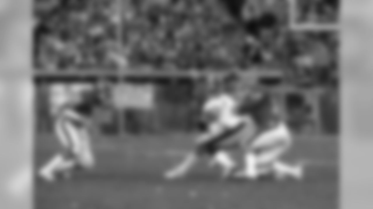 Steve Busick tackles a Steeler while Mike Harden closes in.
