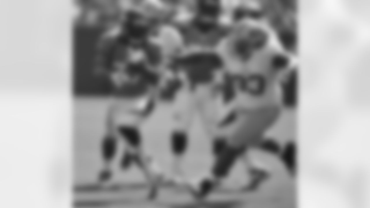 Running back Jeremiah Johnson runs away from 49ers defenders.