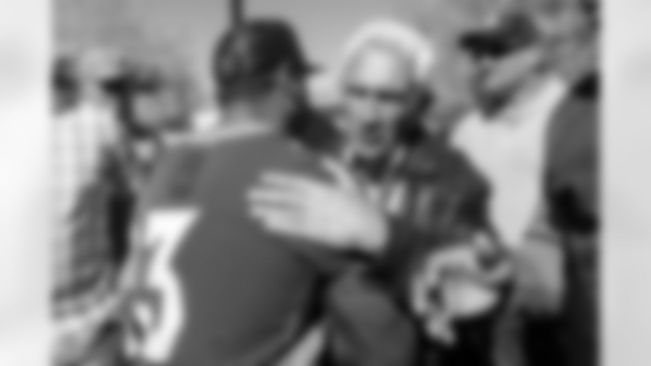 Russell Wilson hugs Mike Shanahan at an alumni visit as part of the Super Bowl XXXII reunion weekend after walkthrough at UCHealth Training Center in Englewood, Colorado on October 22, 2022. (Photo by Ben Swanson)