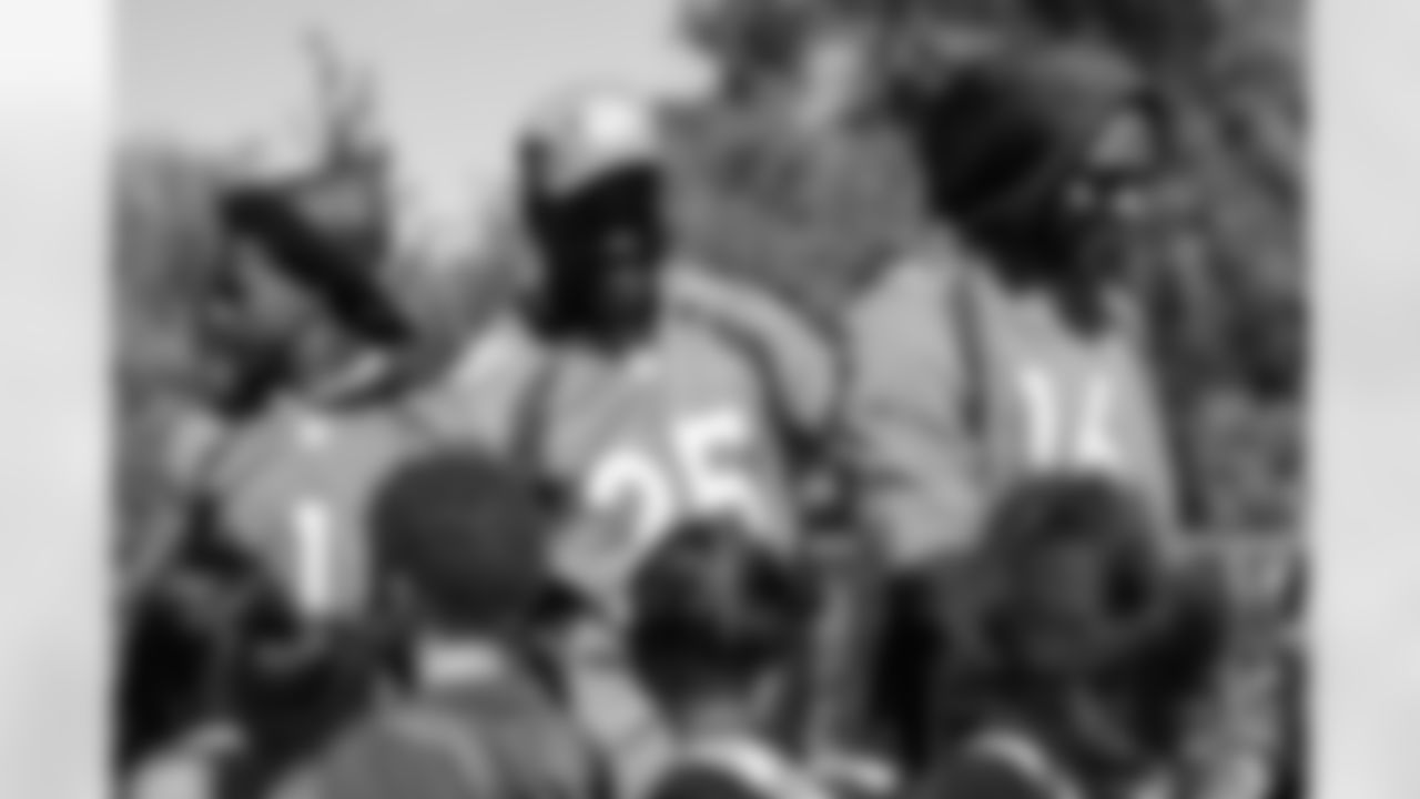 Children high-five KJ Hamler, Melvin Gordon III and Tyrie Cleveland at an event distributing bicycles from Wishes for Wheels to students at John Amesse Elementary School in Denver, Colorado on September 21, 2021. Broncos coaches and front-office staff built the bikes earlier in the month and players distributed them in honor of late former Broncos coach Greg Knapp. (Photo by Ben Swanson)