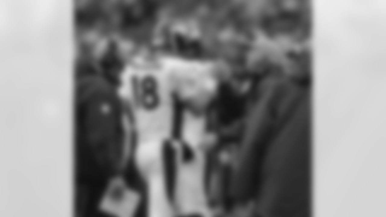 QB Peyton Manning chats with Head Coach John Fox and the rest of the coaching staff on the sideline.