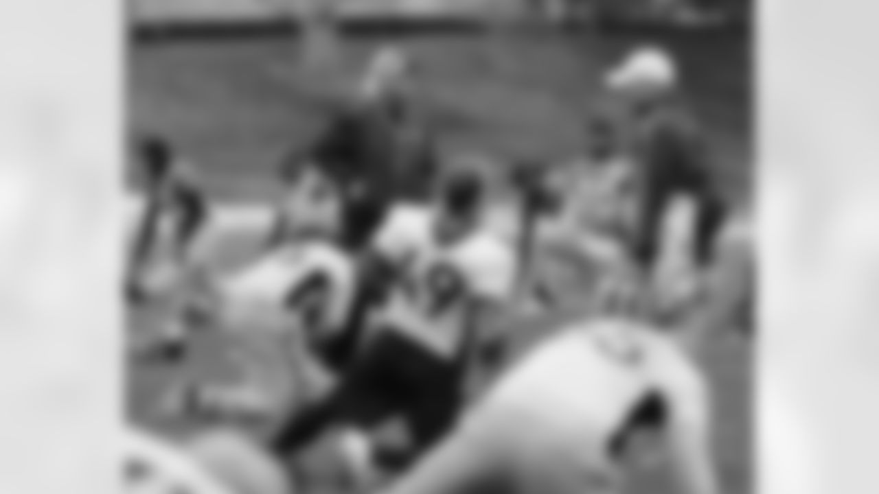 Head Coach John Fox walks around his players during stretching.