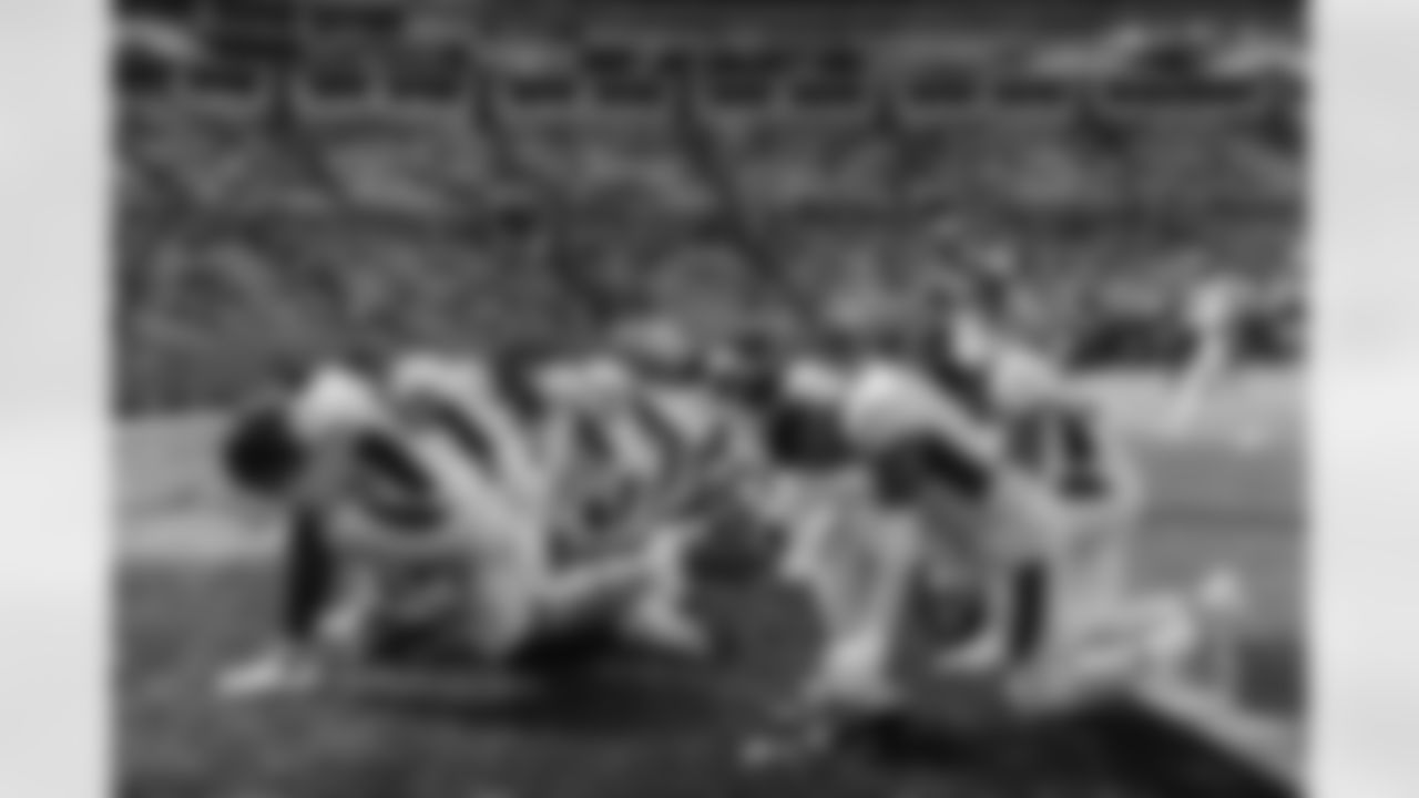 Pat Surtain II, Andrew Beck and others kneel in the end zone in prayer before the Broncos' Week 12 game against the Carolina Panthers at Bank of America Stadium in Charlotte, North Carolina on November 27, 2022. (Photo by Ben Swanson)