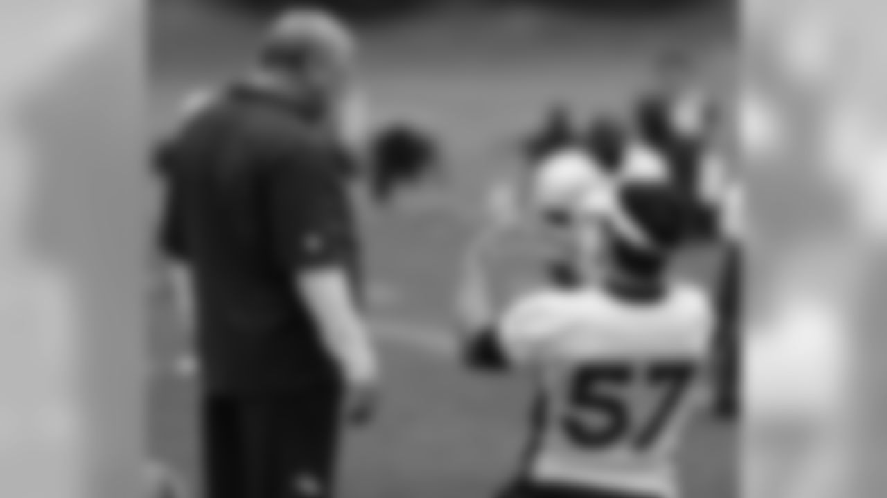 LB Keith Brooking talks with LB Coach Richard Smith during stretching.