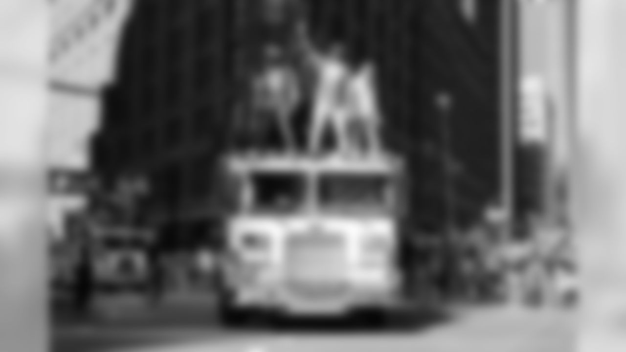 Demaryius Thomas stands atop a fire truck and waves to the crowd during the Broncos' championship parade through downtown Denver on Feb. 9, 2016.