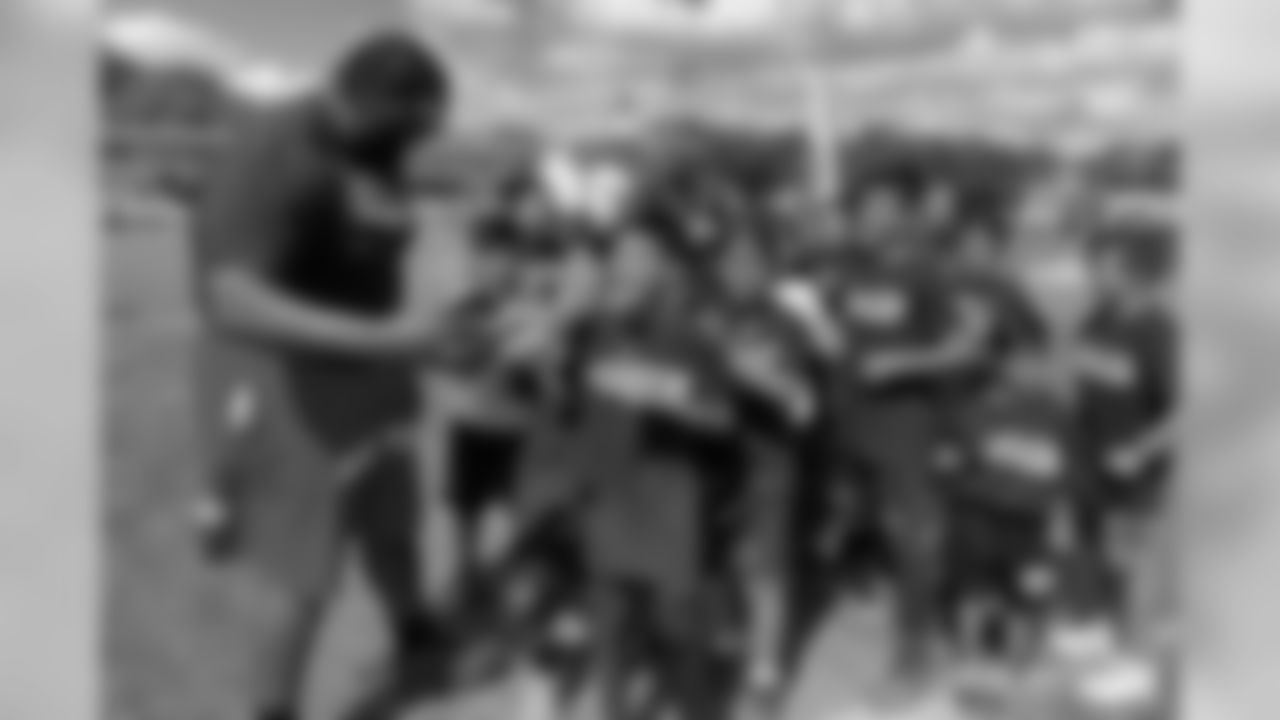 Zach Kerr takes a group photo with children during the Tochito National Tournament on February 9, 2019, as a player ambassador for the flag football tournament.