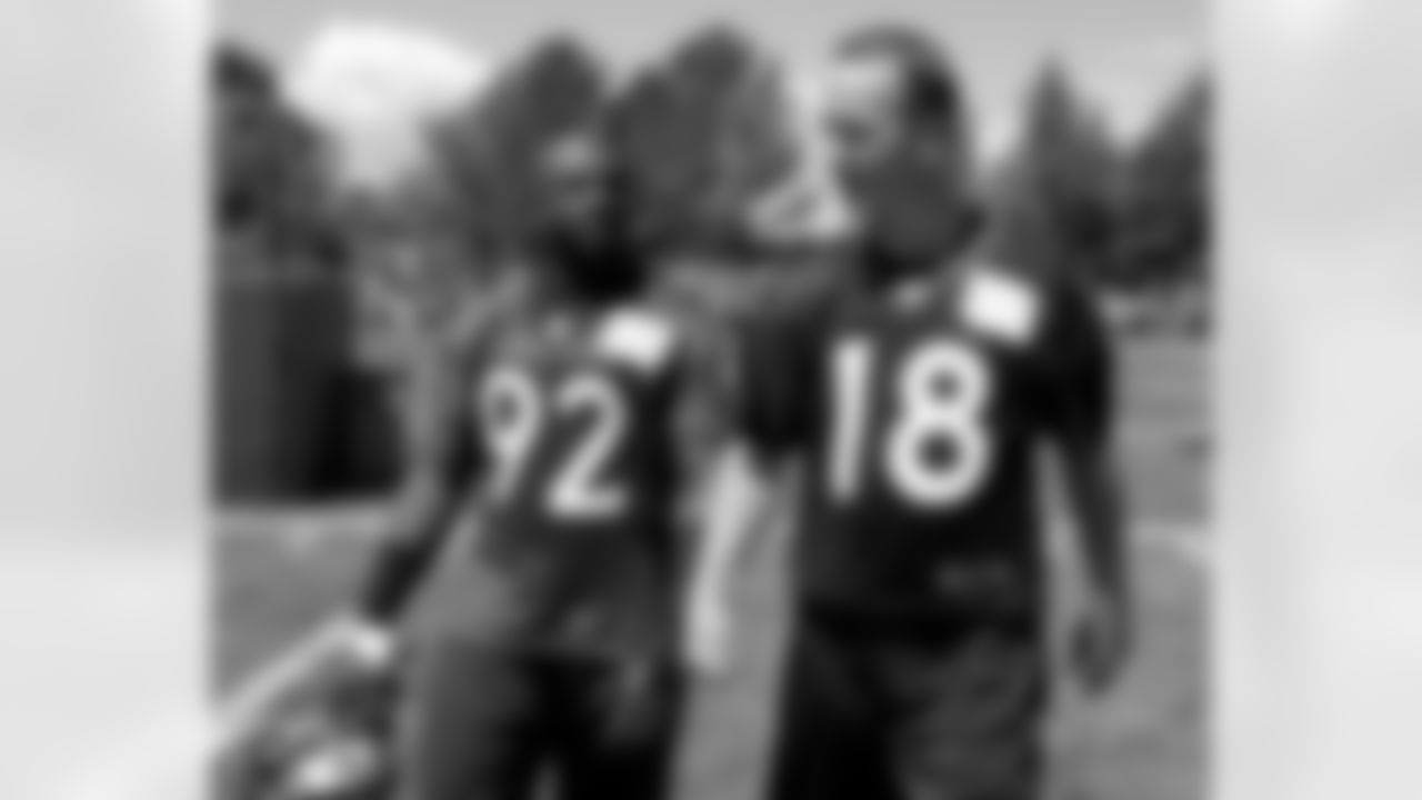 QB Peyton Manning and DE Elvis Dumervil walk off the field together following practice.