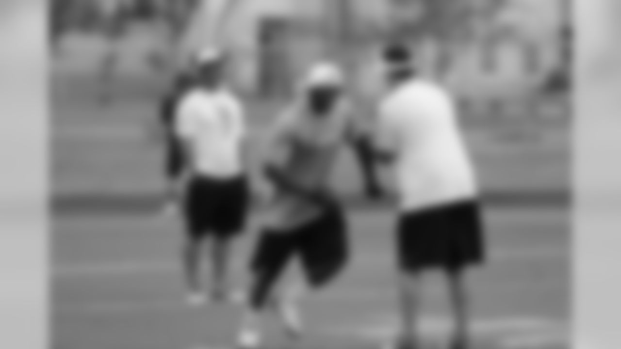 Thomas battles past members of his own coaching staff during practice.