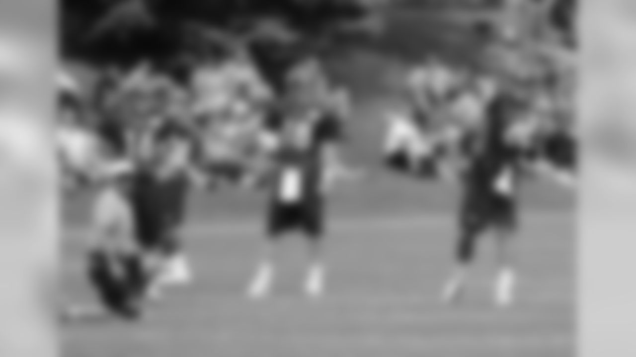 QB Brock Osweiler throws a pass as the rest of the quarterbacks look on.