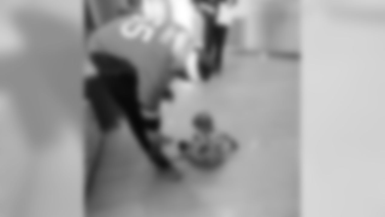A young patient examines Bradley Chubb's shoes during a Build-A-Bear distribution at Children's Hospital Colorado in Aurora on December 17, 2018.