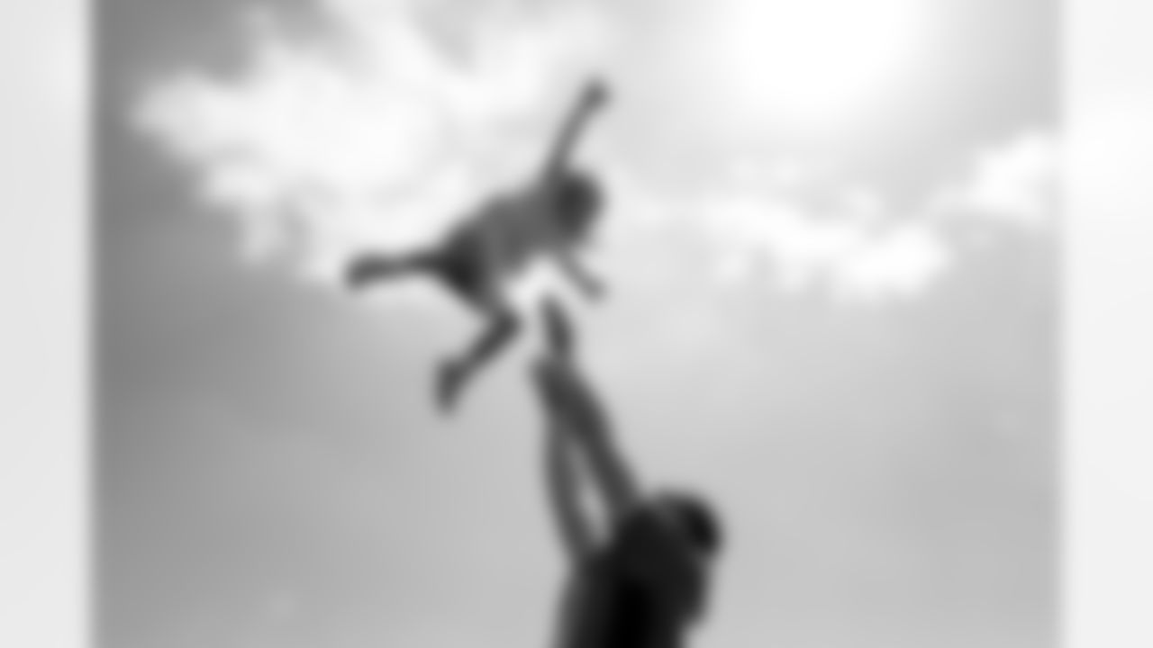 Justin Simmons tosses his daughter Laney into the air after practice on Day 17 of training camp at UCHealth Training Center on August 19, 2021. (Photo by Ben Swanson)