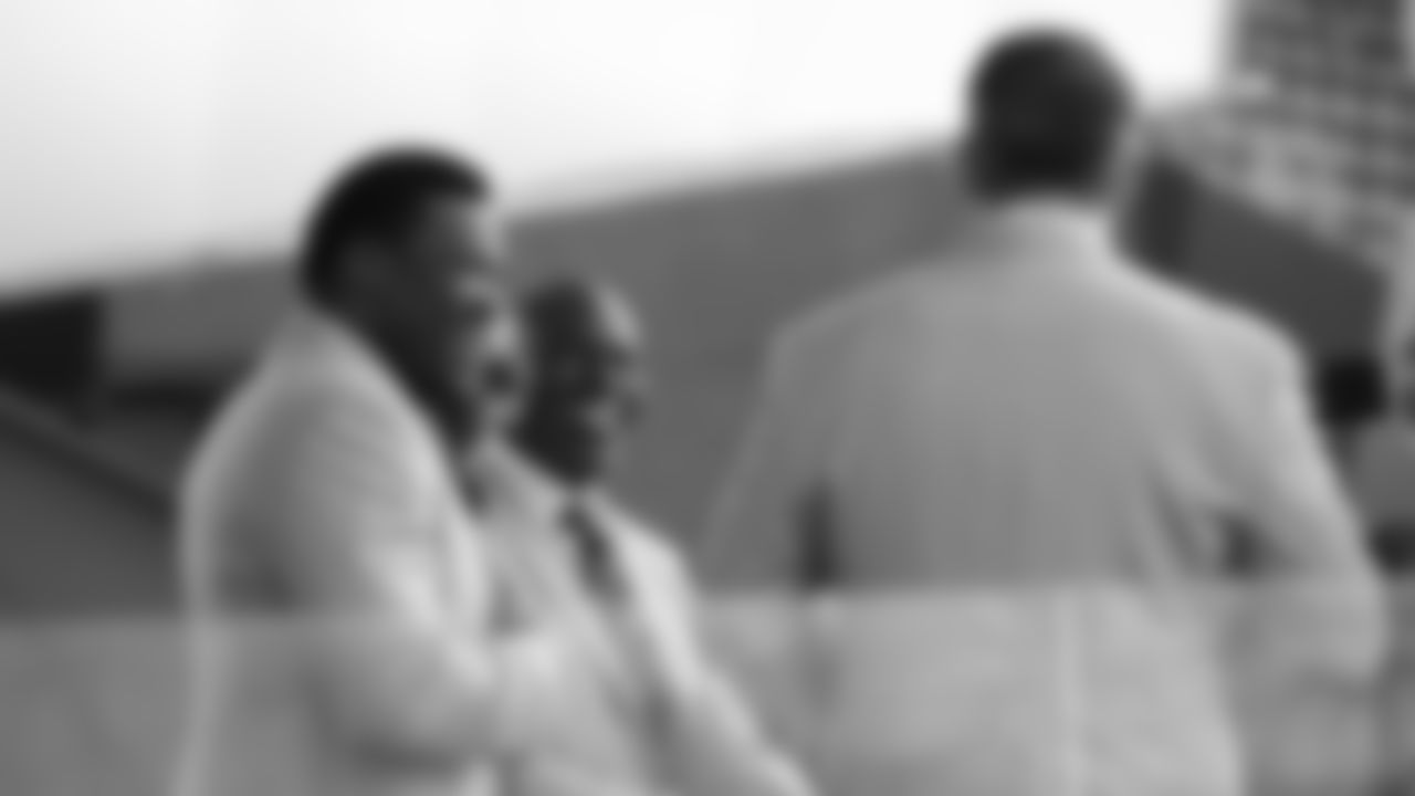 Hall of Fame former Broncos running back Terrell Davis laughs as he talks with Michael Irvin and Kurt Warner on their NFL Network set before the 2019 Pro Football Hall of Fame enshrinement ceremony on August 3, 2019 in downtown Canton, Ohio.
