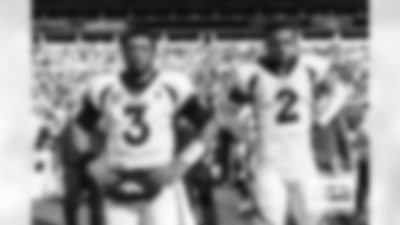 Russell Wilson and Pat Surtain II on the sideline before the Broncos' Week 12 game against the Carolina Panthers at Bank of America Stadium in Charlotte, North Carolina on November 27, 2022. (Photo by Ben Swanson)