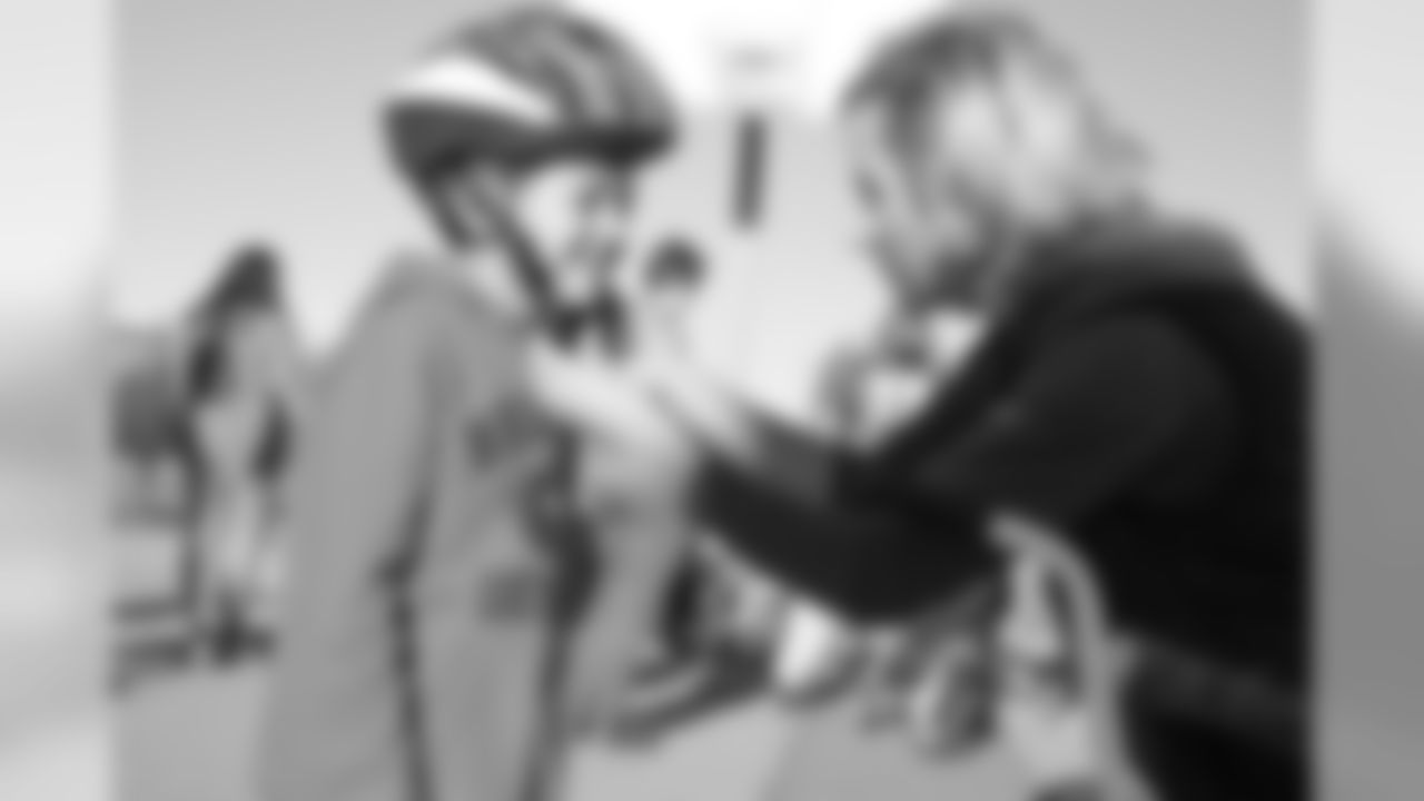 Holly Joseph (right) adjusts a helmet during a bike distribution at Green Valley Elementary School in Denver on December 18, 2018.