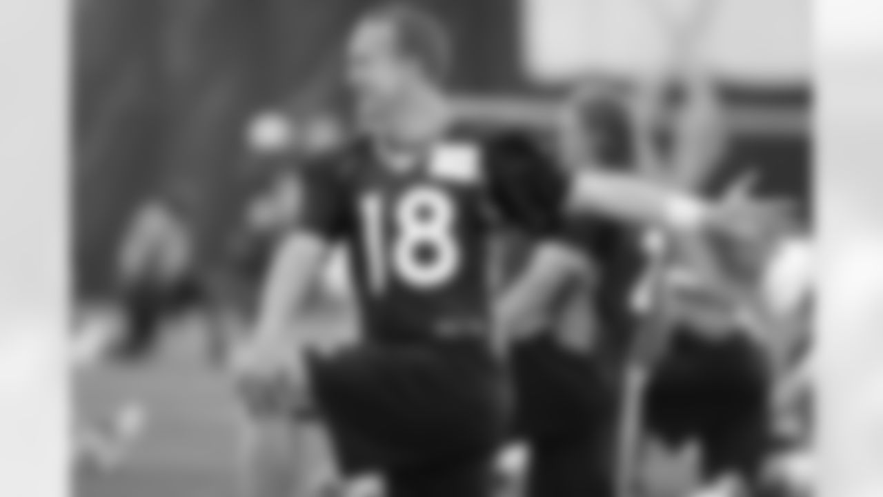 Peyton Manning stretches before the team's practice.