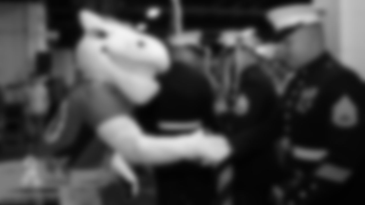 Miles the mascot greets military members in the tunnel before the Broncos' game against the Cleveland Browns at Empower Field at Mile High on November 3, 2019. (Photo by Ben Swanson)