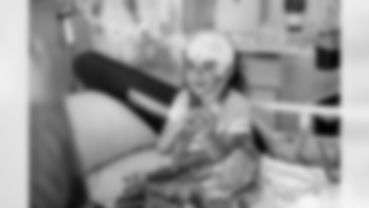 A child holds a toy football during a visit to Children's Hospital Colorado on June 20, 2023 in Aurora, Colorado. Photo by Ben Swanson / Denver Broncos