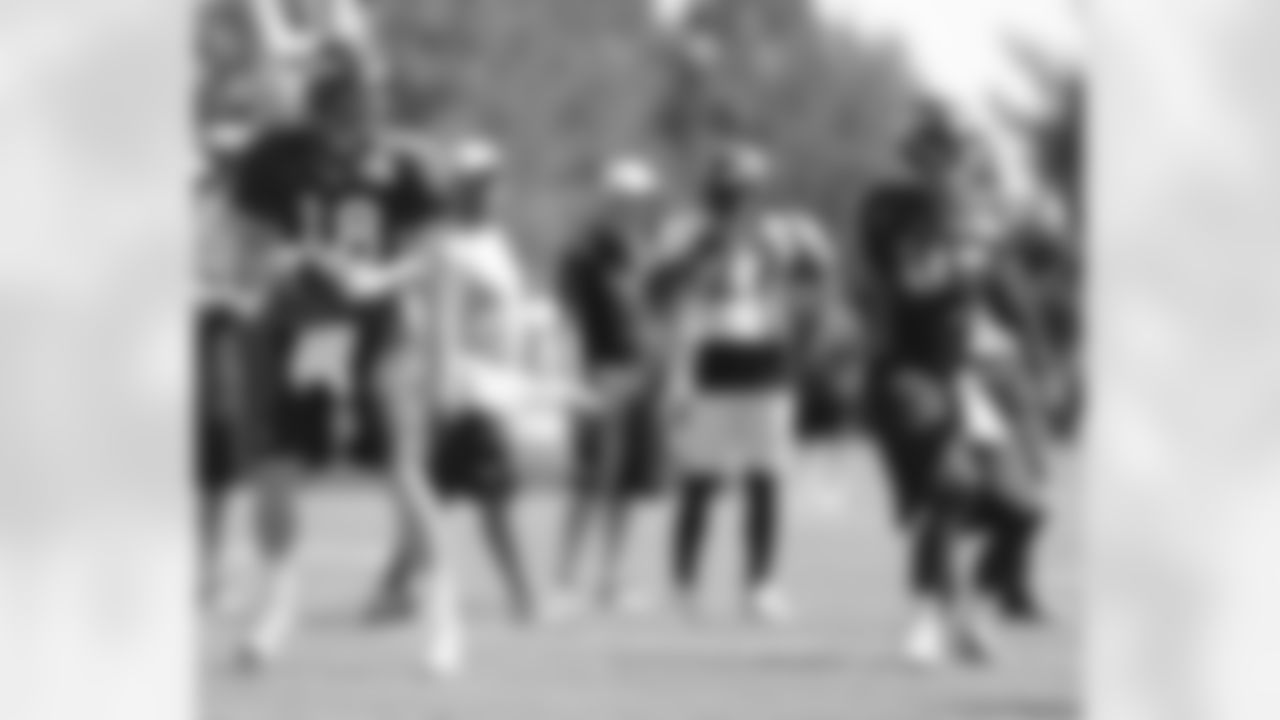 The QBs throw passes during a drill.