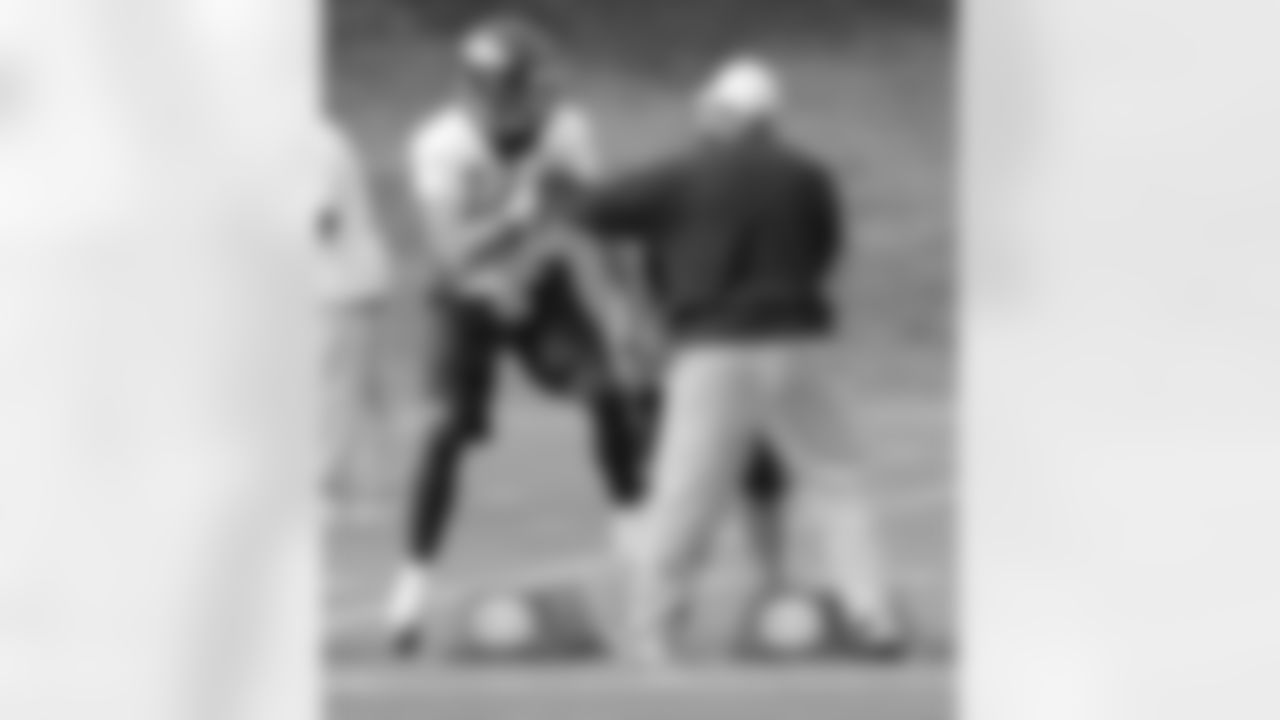 TE Joel Dreessen holds the football tight as RB Coach Eric Studesville tries to knock it out.