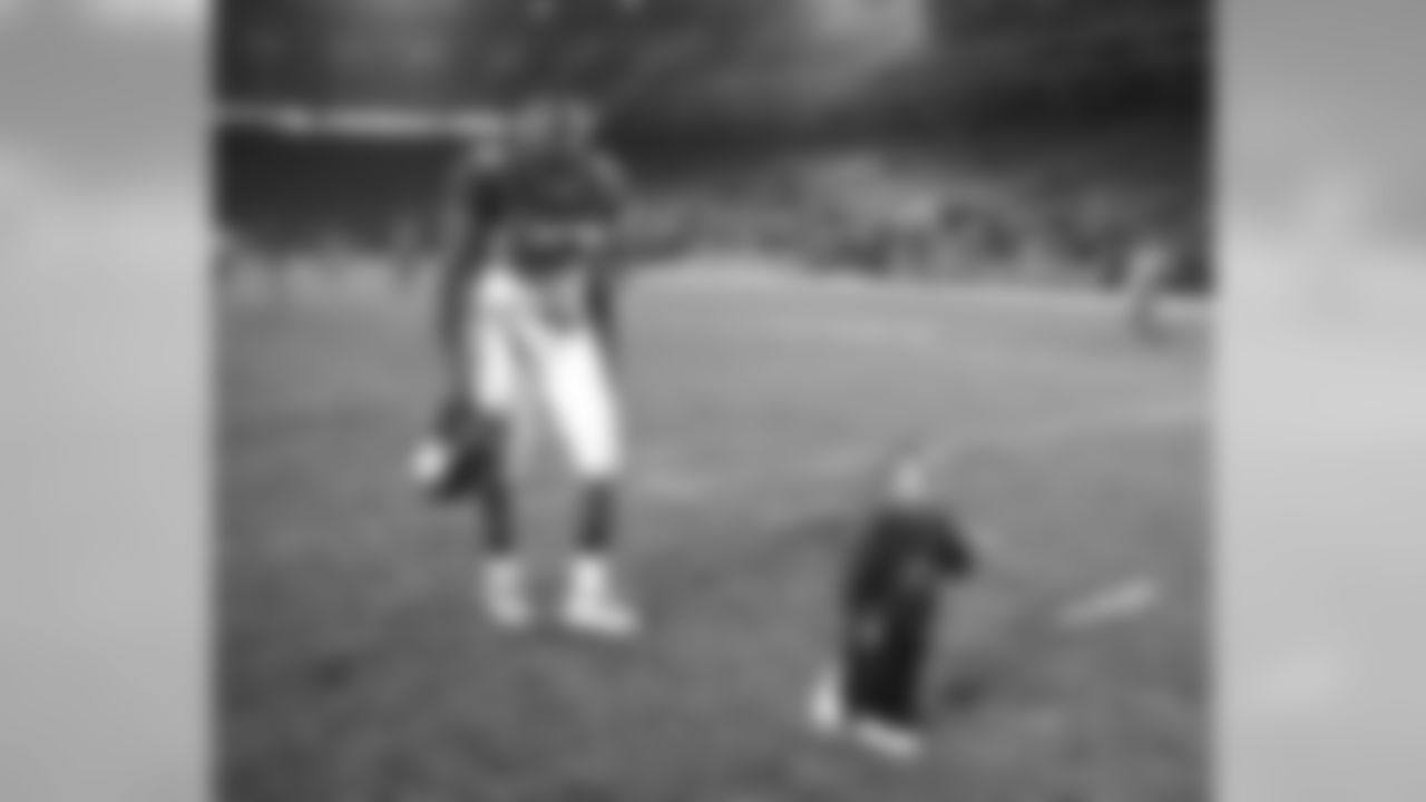 Neil Smith and his son walk off the field after a game against the San Francisco 49ers at Mile High Stadium in Denver, CO on September 3, 1999.