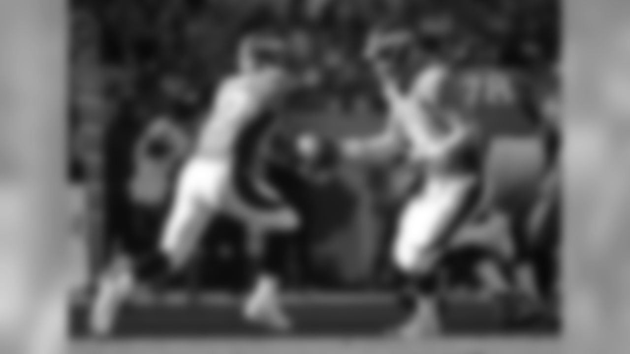 Manning extends the football toward RB Knowshon Moreno in the backfield.
