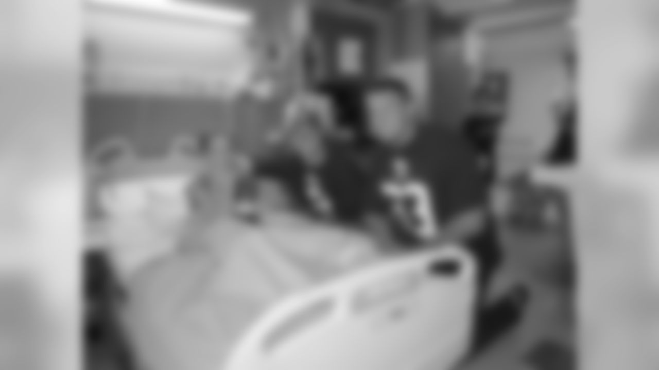 Adam Weber and Ben Garland meet with a young Broncos fan at the Rocky Mountain Hospital for Children on June 9.