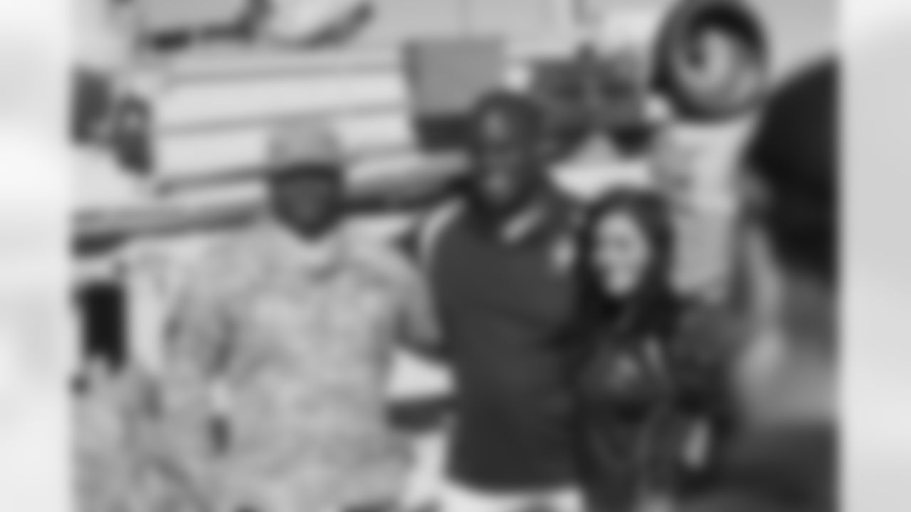 Rivers and Chelsie take a picture with a soldier.