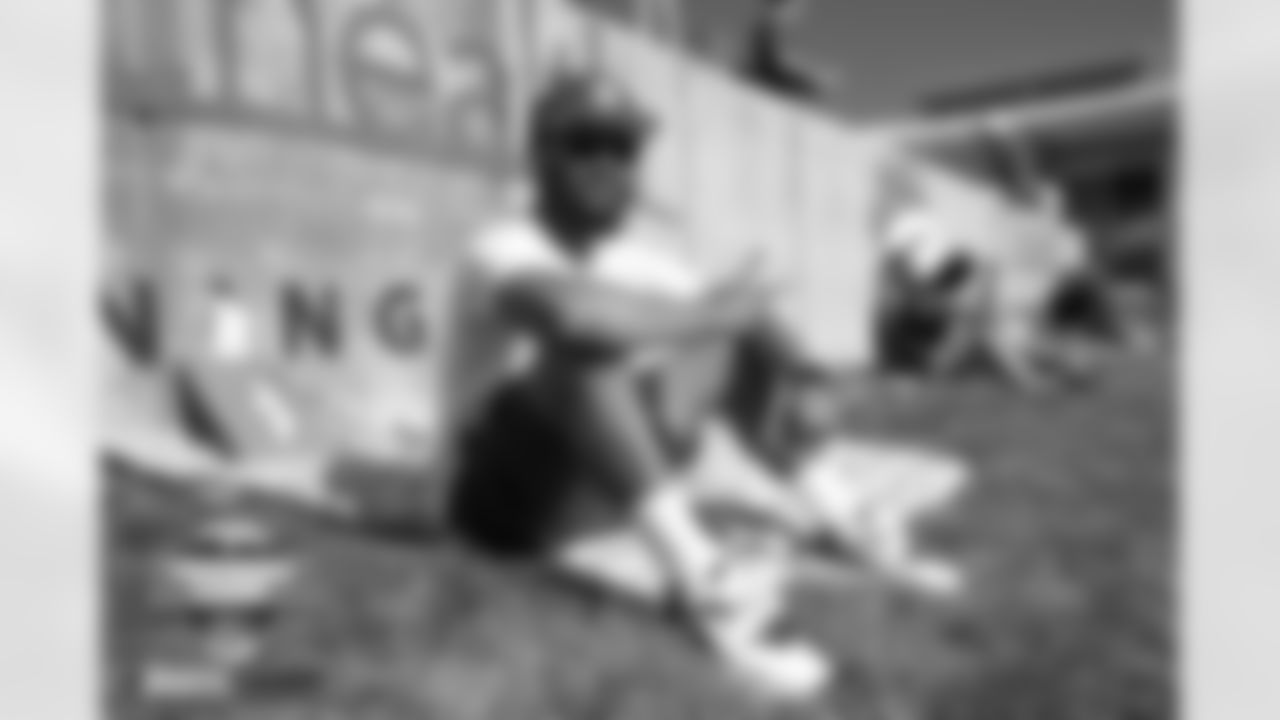 A fan sits on the berm at practice on Day 4 of training camp at UCHealth Training Center in Englewood, Colorado on July 30, 2022. (Photo by Ben Swanson)