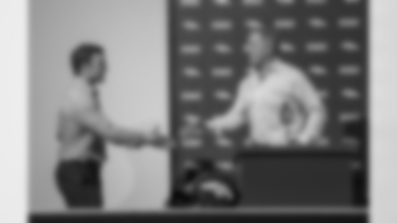 Wes Welker shakes hands with EVP of Football Ops John Elway at his introductory press conference.