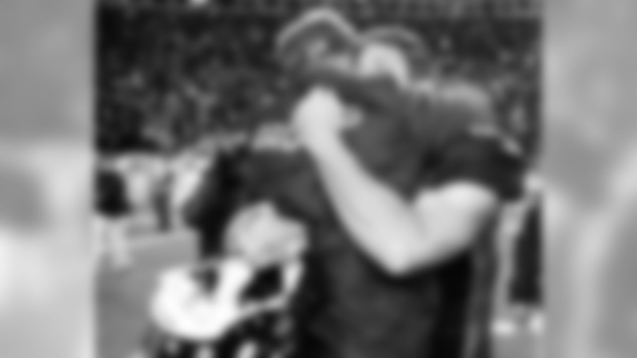Denver Broncos Tim Tebow hugs offensive coordinator, Mike McCoy, after the win against the Pittsburgh Steelers in the NFL AFC wildcard playoff game January 8, 2012 at Sports Authority Field at Mile High in Denver Colorado.